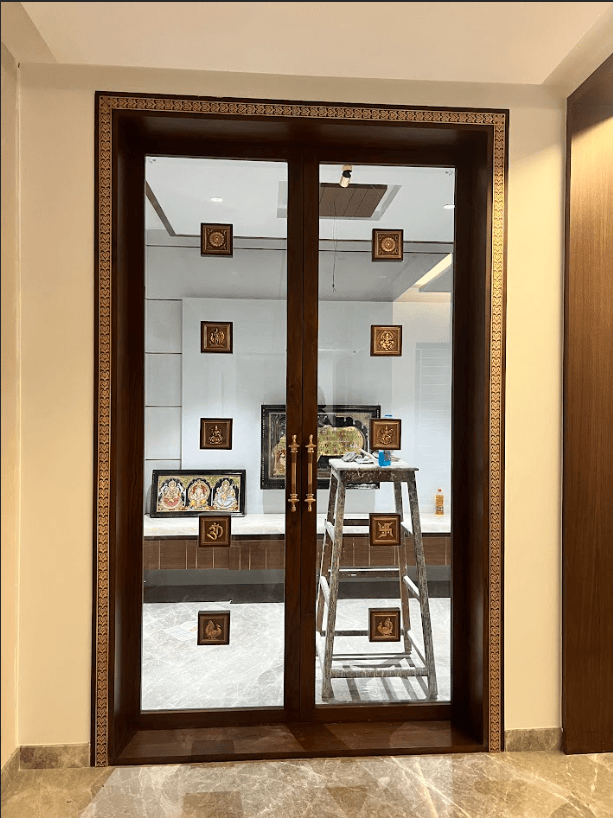 Traditional pooja room with carved teak doors